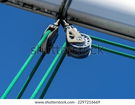 A buoyant hoist installed on the yacht that is tied with a green rope attached to the sail.