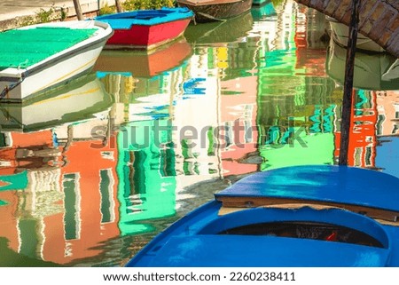 Burano island canal reflection, colorful houses and boats, Venetian lagoon