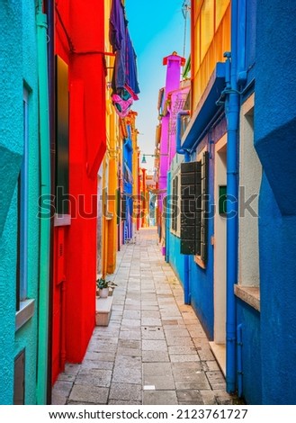 Burano island narrow street, colorful houses in the venetian lagoon. Venice, Italy, Europe.