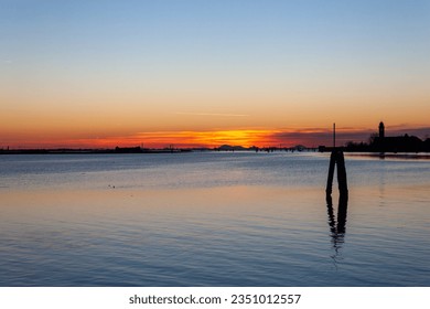 Burano, Italy - February 12, 2023: Sunset over the Venice lagoon seen from Burano island. - Shutterstock ID 2351012557