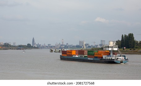 Burcht, Antwerp, Belgium 26 September 2021 : containership on the river Scheldt with the city skyline of Antwerp in the background