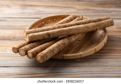 Burdock in a bamboo colander placed in the background of a wooden board