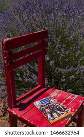 Burdur / Turkey - July 7, 2019 ; Book Concept For School. The Woman Reading Charles Dickens,A Tale Of Two Cities Book And Fan On The Red Wooden Table At The Lavender Field.