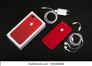 BURGAS, BULGARIA - AUGUST 7, 2018: Apple iPhone 7 Plus Red Special Edition on black background, back side. Charger, earpods and adapter.