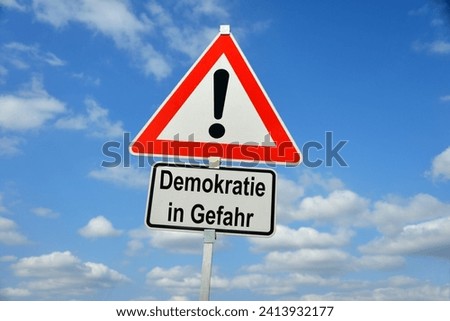 Burgdorf, Lower Saxony, Germany - January 16, 2024: Traffic warning sign saying Democracy in danger (in German Demokratie in Gefahr)