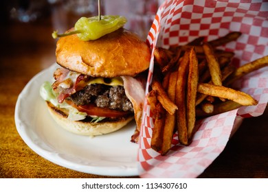 Burger with bacon, cheese and jalapeno pepper and french fries on the side. - Powered by Shutterstock