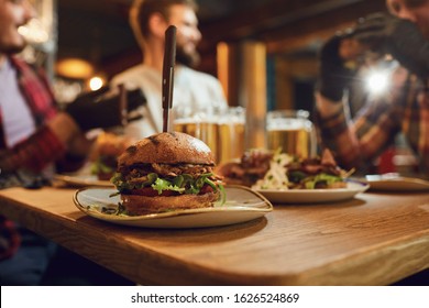 Burger With Beer On The Table In A Bar Pub.