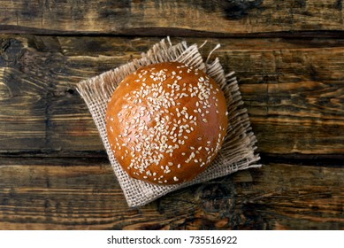 Burger Bun With Sesame Seeds On Wooden Background, Top View