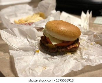 Burger From Diner Unwrapped On Table