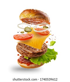 Burger with flying elements. Delicious burger with flying ingredients isolated on white background. Flying Burger Slices - Shutterstock ID 1740539612