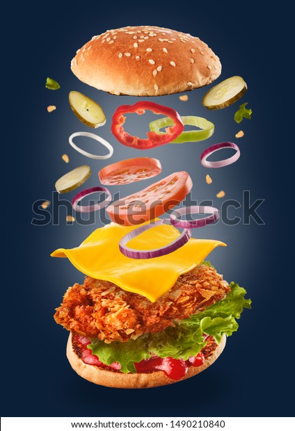 Burger with flying\
ingredients. Delicious monster Hamburger cheeseburger explosion\
concept flying\
ingredients.