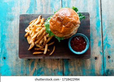 Burger And French Fries Served With Ketchup On Blue Wooden Table At Cafe Shot From Top