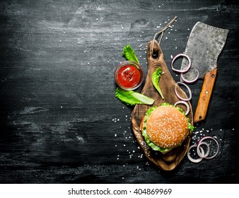 The Burger and the fresh ingredients on the old Board. On a black chalkboard.  Top view. - Powered by Shutterstock