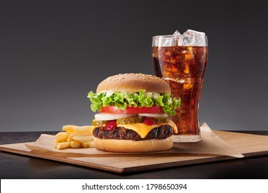 burger, fries and coke on the wood table