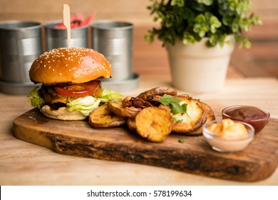 burger and fries on a wooden table 