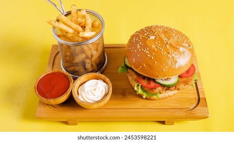 Burger and fries on wooden tray on yellow background - Powered by Shutterstock