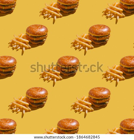 
burger with fries on yellow background