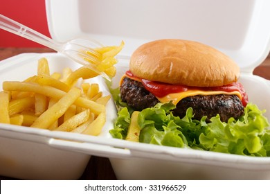 Burger And Fries Portion In Takeout Food Box With Plastic Fork , Closeup