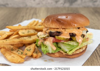 Burger With Lettuce, Tomato, Pickle, And Secret Sauce With Pepper Steak Fries For A Party Appetite Hunger Meal.