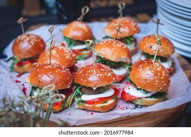 Burger Mini Burgers Snacks On A Wooden Table With Craft Paper, Beautifully Decorated Catering Banquet Table On A Corporate Christmas Birthday Party Event Or Wedding Celebration 