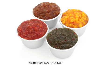 Burger Relish Selection Of   Tomato, Sweetcorn, Onion And Gherkin  In Four Metal Serving Dishes, Over White Background.