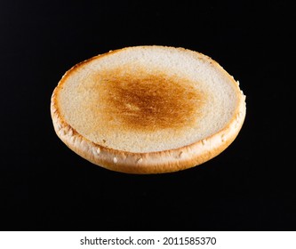 Burger Ruddy Bun Toasted With Sesame Seeds On Black Background Close-up Macro