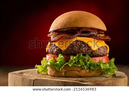 Burger with salad, cheedar cheese and bacon.