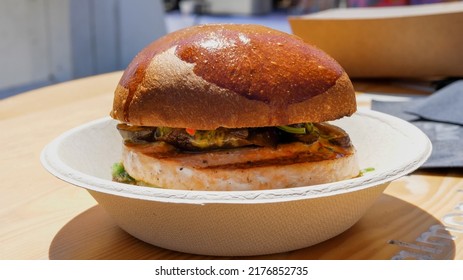 Burger With Salmon Cutlet On A Disposable Plate