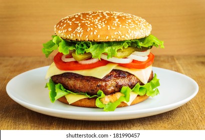 Burger In A White Plate On Wooden Table