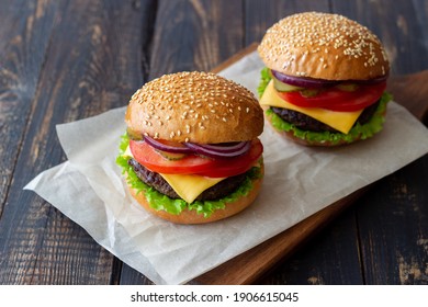 Burgers with cutlet, tomato, lettuce, cucumber, onion and cheese. American cuisine Fast food Cheeseburger