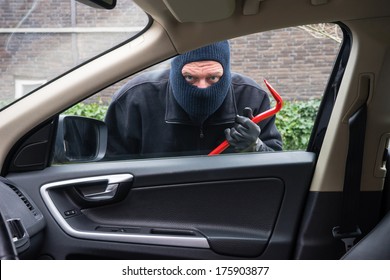 A Burglar In Action To Rob Something Out Of A Car