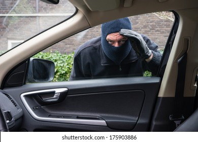 A Burglar In Action To Rob Something Out Of A Car