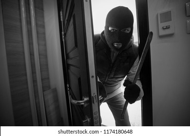 
Burglar Breaking Door Of House With Crowbar