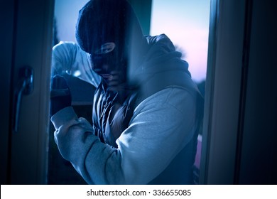 burglar with crowbar to break door to enter the house - Shutterstock ID 336655085