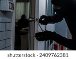 Burglar forcing open a house door