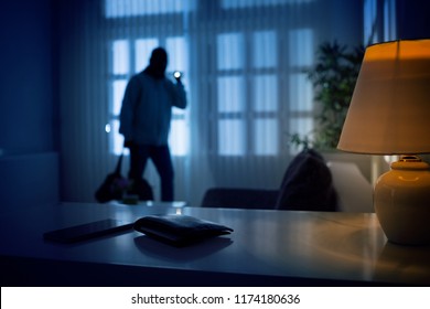 Burglar or intruder inside of a house or office with flashlight