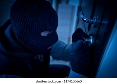 burglar or thief breaking the lock of a door