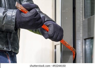 Burglar trying to break into a house with a crowbar