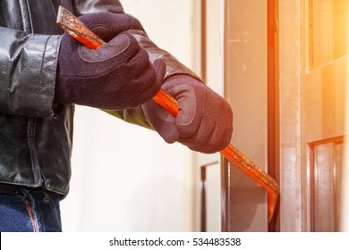 Burglar trying to break into a house with a crowbar