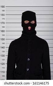 Burglar Wearing Balaclava Standing Against Police Lineup