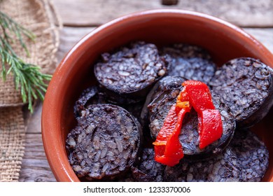 Burgos blood sausage casserole and red pepper on rustic table.