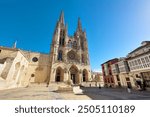 Burgos, Spain - October 18, 2022: Burgos Cathedral with people and tourists walking in the square next to the Cathedral of Saint Mary, in Burgos, Spain.