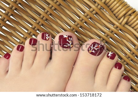 	 Burgundy pedicure with a picture of the women's nails on a background.