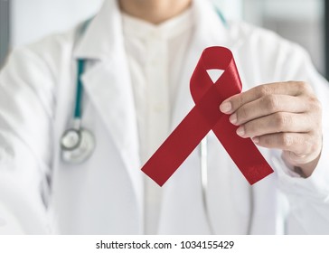 Burgundy ribbon in doctor’s hand, symbolic bow color for multiple myeloma cancer, adults with disabilities awareness support, headaches migraines and Sickle-Cell Anemia