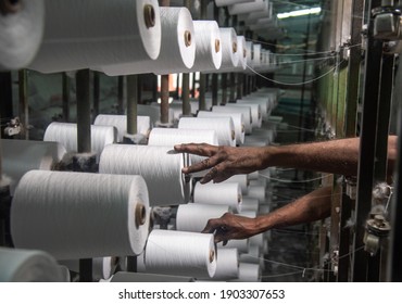 BURHANPUR, MADHYA PRADESH, INDIA 05 JAN 2021:A Loom factory worker work on Cotton Thread Bobins on a copwinder weft assembly line loom in.BURHANPUR, MADHYA PRADESH, INDIA 
