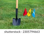 Buried electric, natural gas and water utility warning flag with shovel. Notify utility locate company for underground utilities, call before you dig and digging safety concept