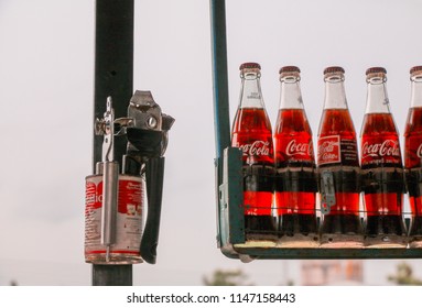 Burirum, Thailand - July 27,2018: Coca-Cola/Coke Classic Glass Bottles Display On The Old Metal Shelving Beside A Carnation Milk Can With A Can Opener.