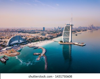 Burj Al Arab Luxury Hotel And Dubai Marina Skyline In The Background At Sunrise