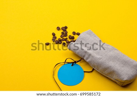 Burlap sack full of coffee beans on yellow background