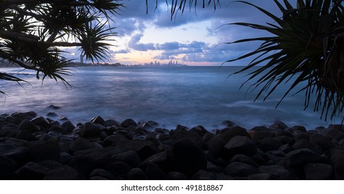 Burleigh Heads on the Beach with Pandanus Trees and a Rocky Coastline Overlooking the Iconic Gold Coast Skyline During a Peaceful Sunset, Queensland, Australia